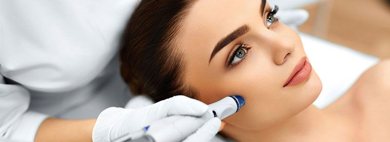 Doctor applying medical wand to the side of a woman's face